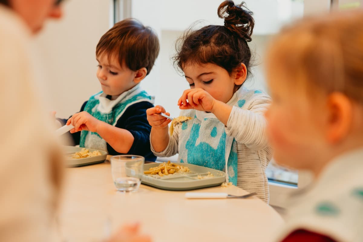 Enfants qui mangent ensemble à la cantine de la crèche
